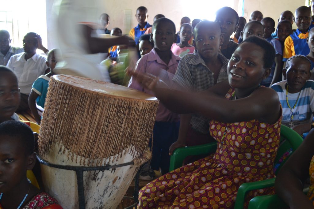woman bangs drum with her hand during Mass