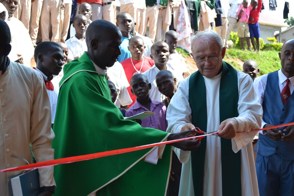 2 priests cut ribbon for ceremony