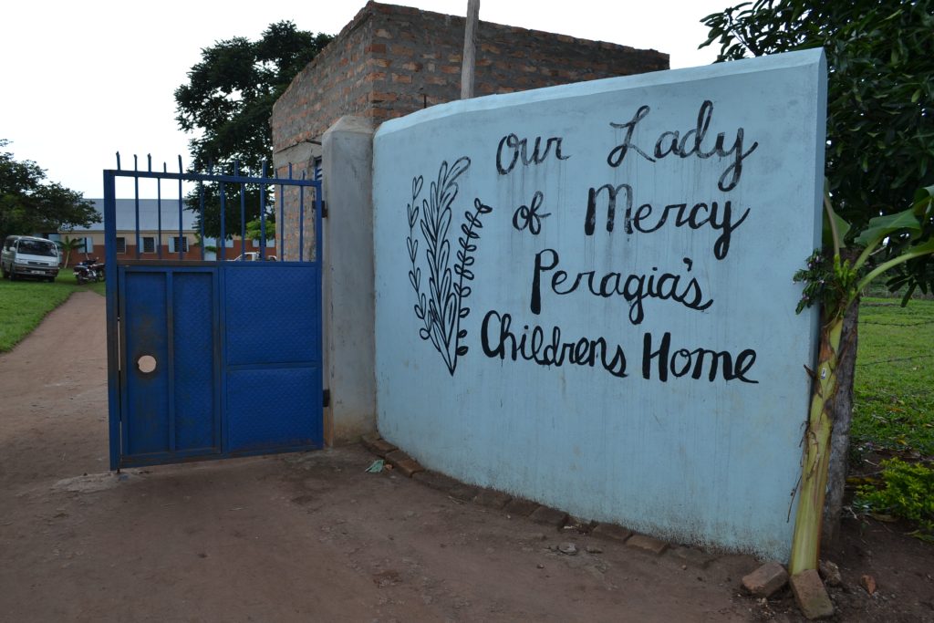 sign painted on white wall at entrance to orphanage